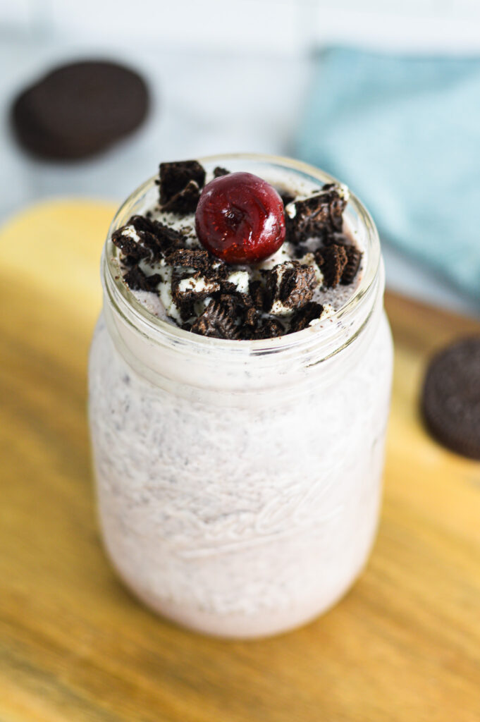 Cherry Oreo Milkshake topped with cookie pieces and a sweet cherry.