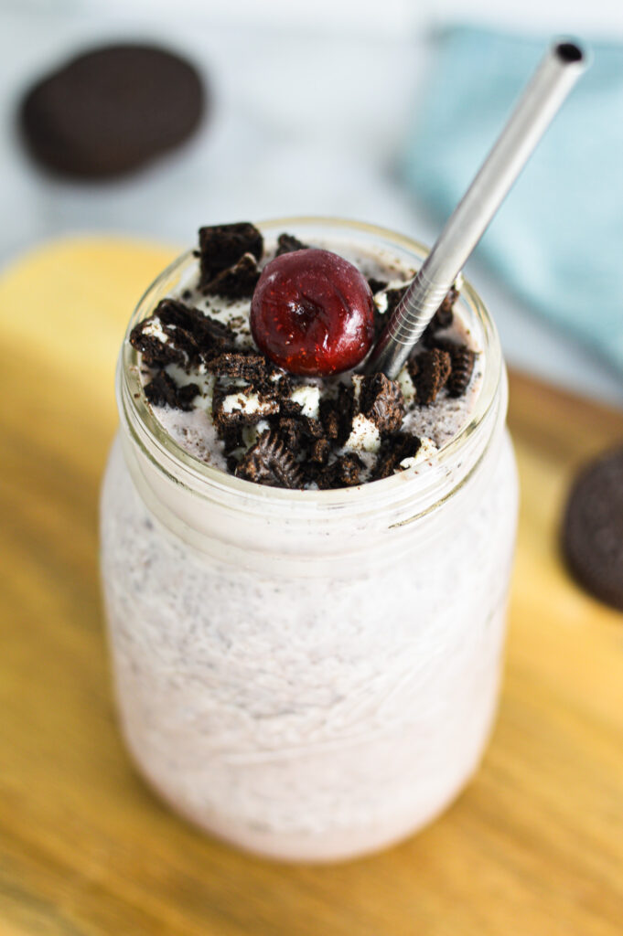 Cherry Cookies and Cream Milkshake topped with crushed Oreos and a large cherry.