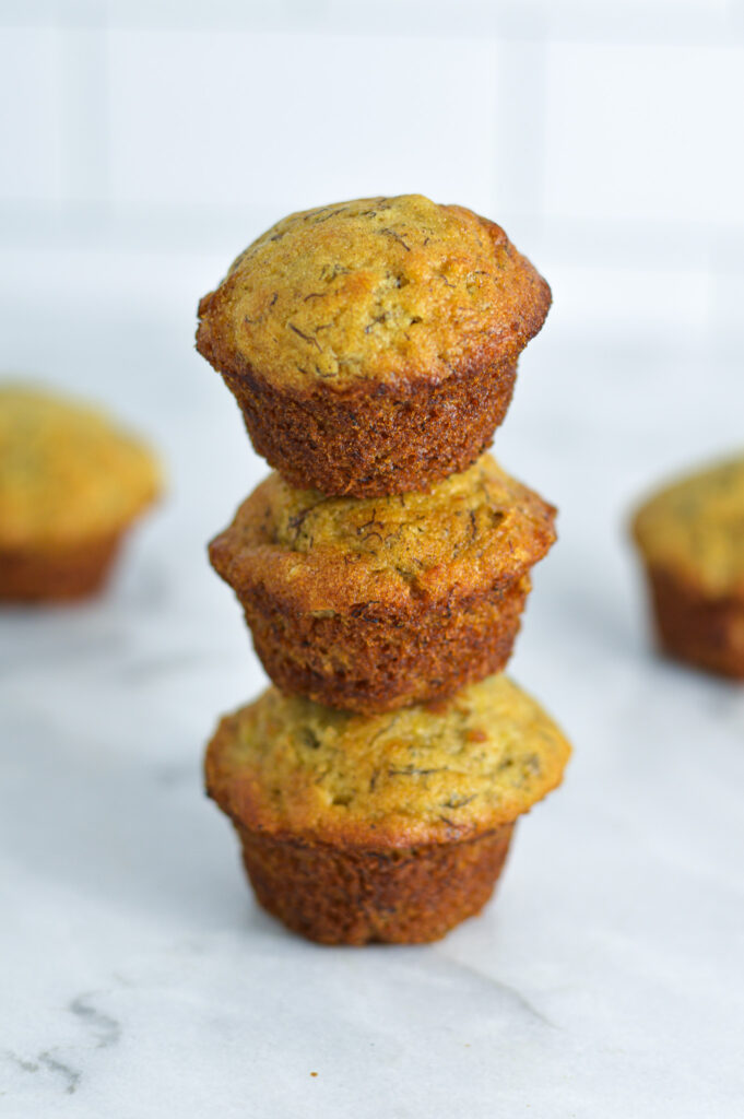 Three Mini Banana Muffins stacked with no paper liners.