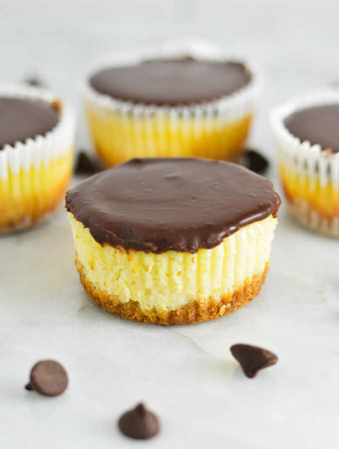 Creamy Mini Chocolate Ganache Cheesecakes with some cheesecakes without paper liners.