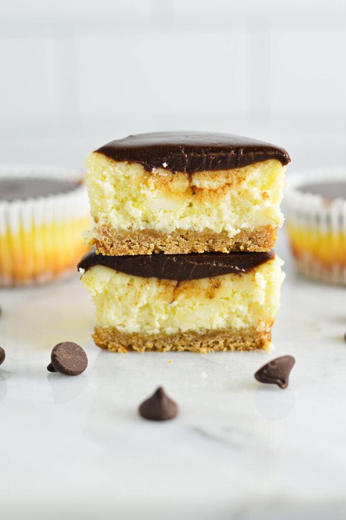 Mini Chocolate Ganache Cheesecakes cut in two to reveal a creamy cheesecake layer.