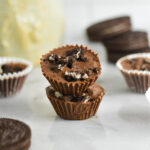 A stack of two Mini Oreo Nutella Cups with Oreo cookies in the background.