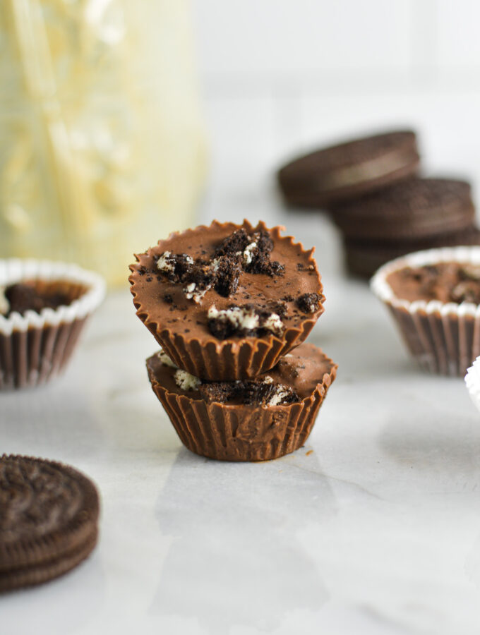 A stack of two Mini Oreo Nutella Cups with Oreo cookies in the background.