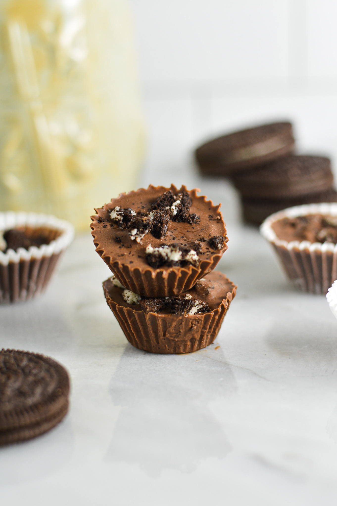 A stack of two Mini Oreo Nutella Cups with Oreo cookies in the background.