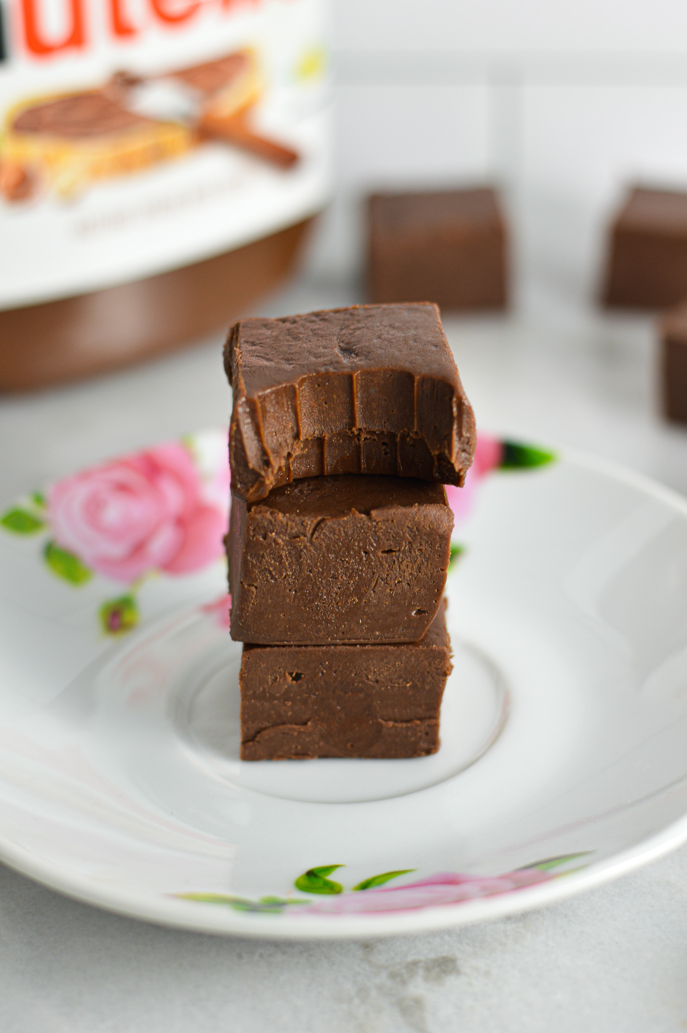 A stack of three Nutella Fudge with a bite taken out of the top one.