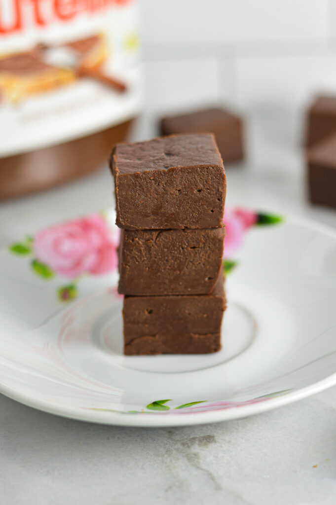 A stack of 3 Nutella Fudge pieces on a small white plate.