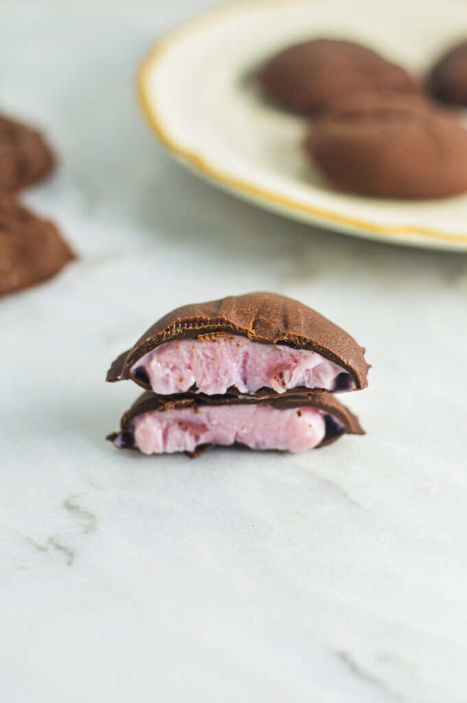 A chocolate yogurt cluster cut in half to reveal the smooth yogurt filling.