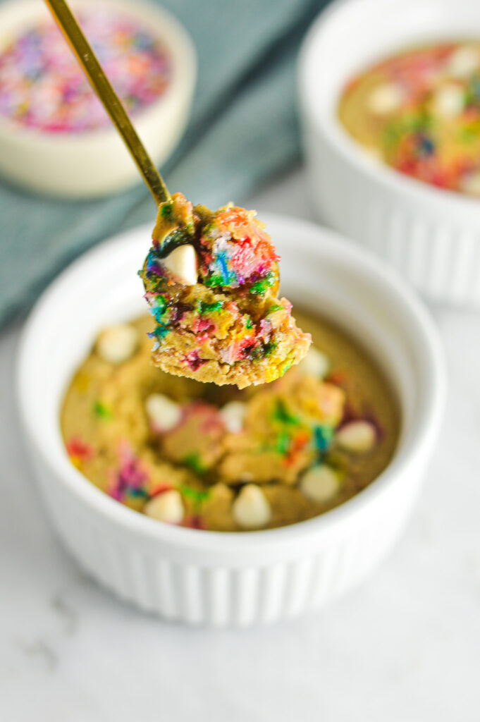 A golden spoon holding a scoop of Cake Batter Protein Blended Baked Oats. 