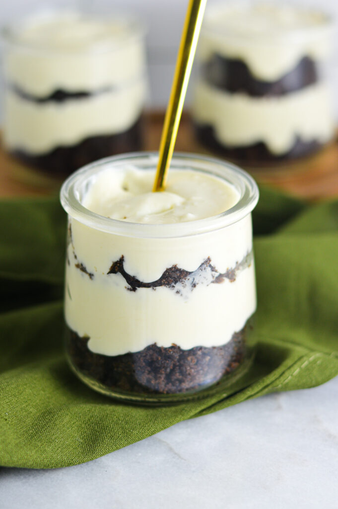 Chocolate Cake Cheesecake Cups with a small golden spoon coming out of the one in the foreground.