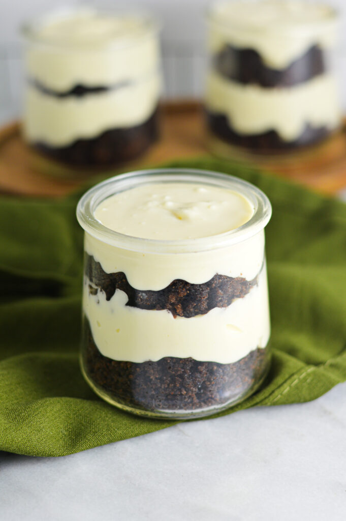 A small glass jar with layers of rich chocolate cake and creamy cheesecake.