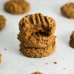 A stack of soft Peanut Butter Mocha Protein Cookies with a bite taken out of the top cookie.