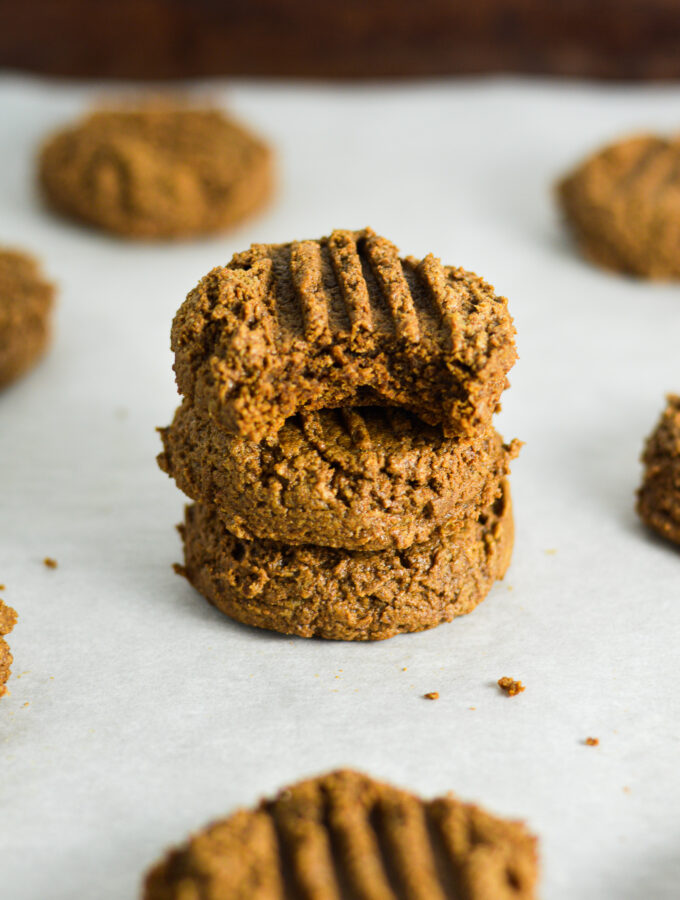 A stack of soft Peanut Butter Mocha Protein Cookies with a bite taken out of the top cookie.