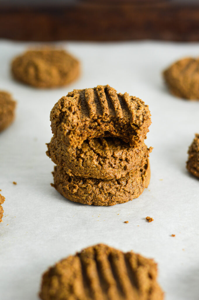 A stack of soft Peanut Butter Mocha Protein Cookies with a bite taken out of the top cookie.