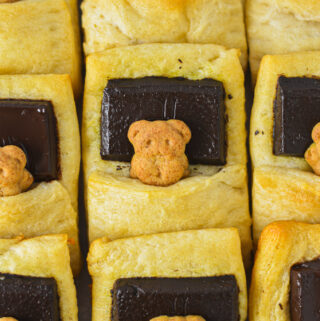 Bears in a Blanket wrapped in golden brown crescent roll dough with a piece of dark chocolate as the graham cracker bear's pillow.