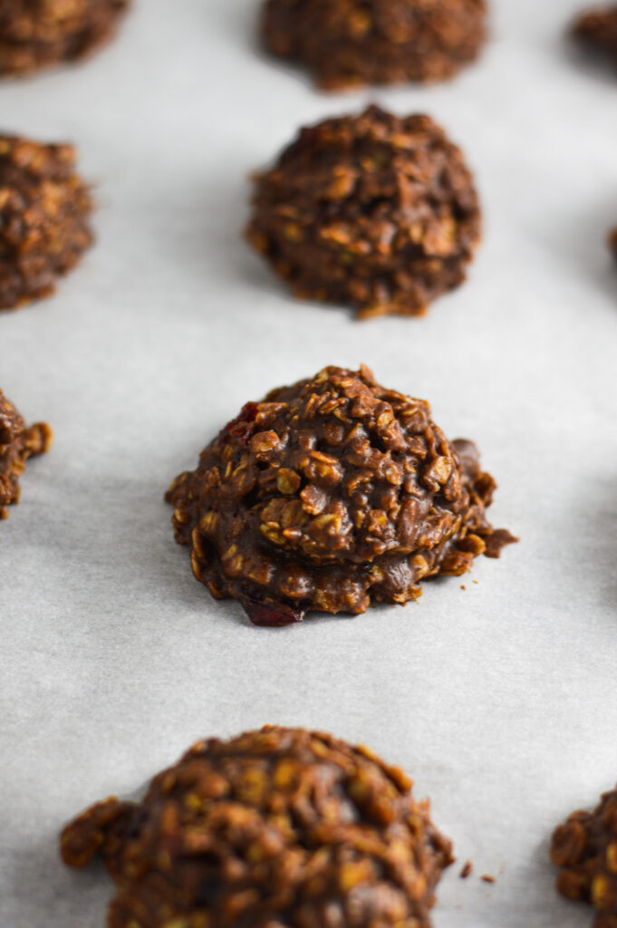 A cookie sheet with wax paper and No Bake Nutella Cranberry Oatmeal Cookies lined on it.