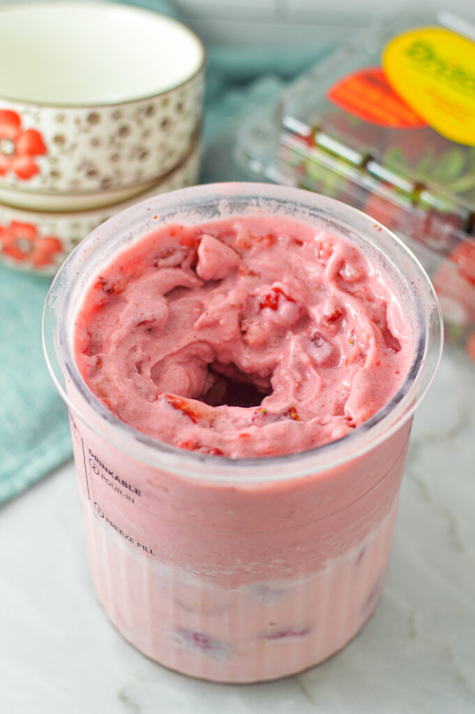 A Ninja Creami pint filled with 3 Ingredient Ninja Creami Strawberry Ice Cream.