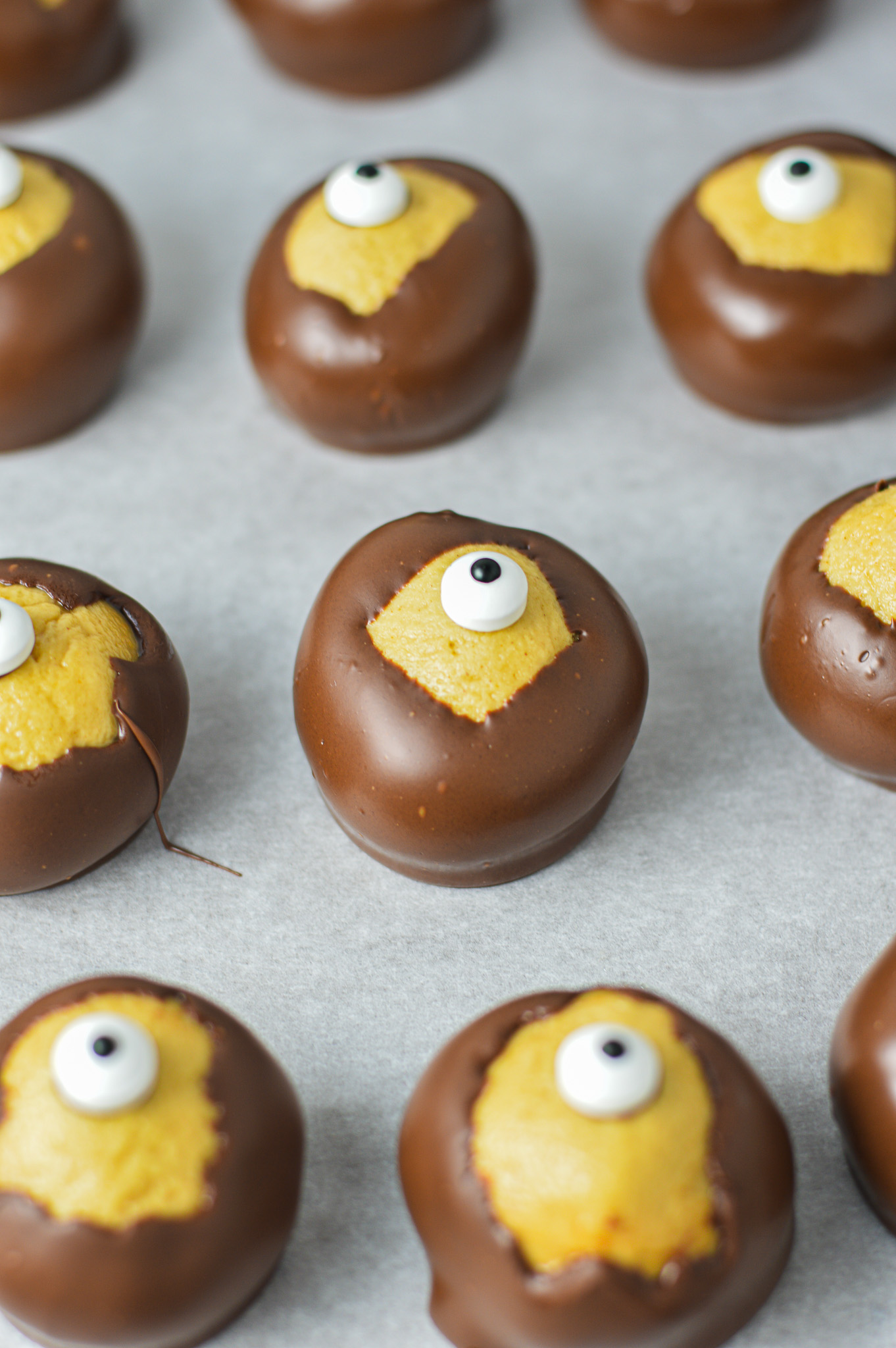 Some Eyeball Buckeyes on a parchment paper lined cookie sheet.