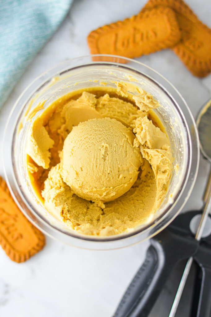 A pint of Ninja Creami Biscoff Ice Cream showing an ice cream scoop of the indulgent dessert.