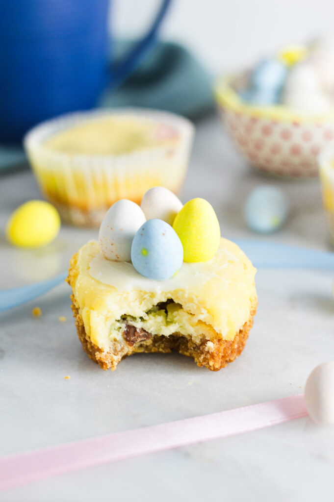 A bite taken out of a Easter Egg Mini Cheesecake, topped with pastel colored mini eggs.