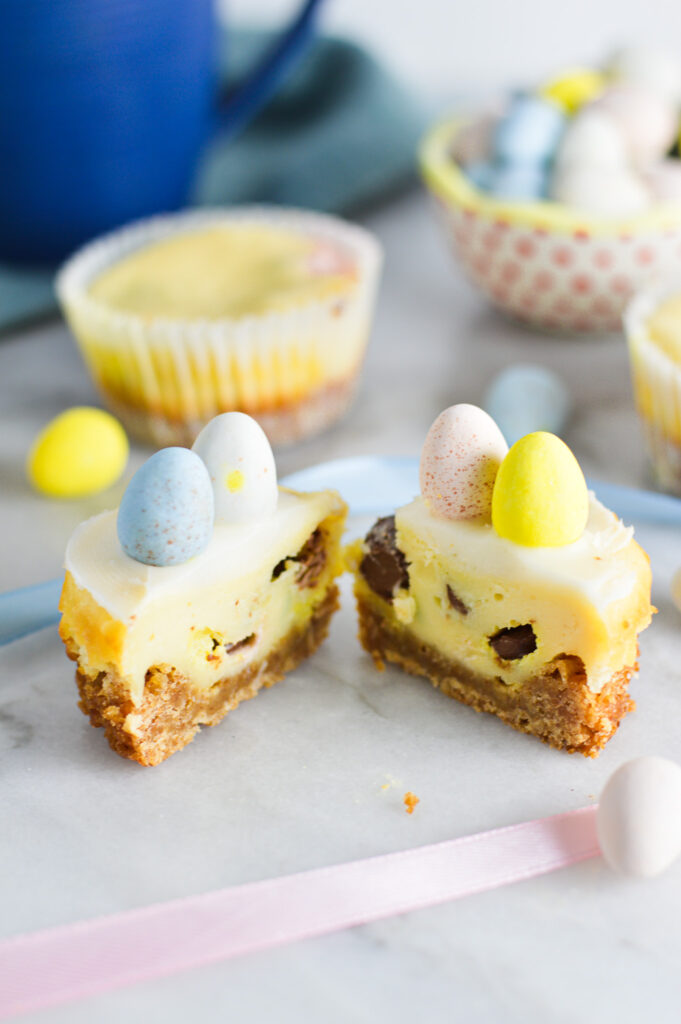 A Easter Egg Mini Cheesecake cut in half, showing the chopped mini eggs in the creamy center.