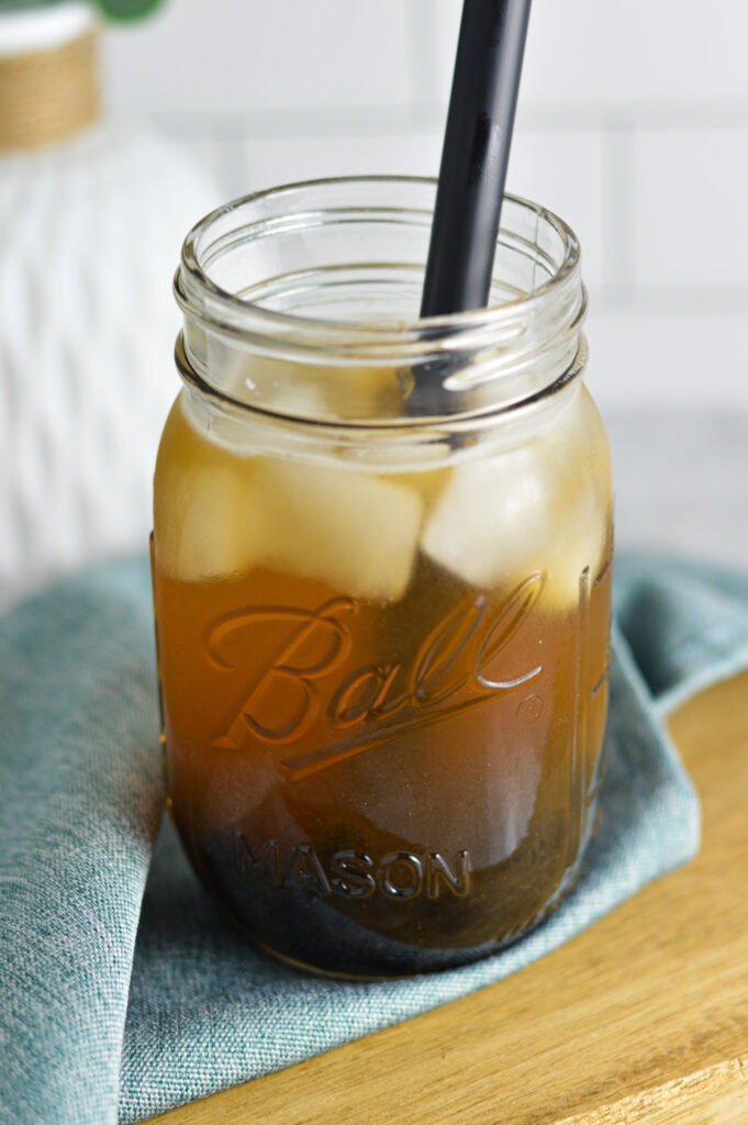 Iced Honey Green Bubble Tea with a black boba straw coming out of the mason jar.