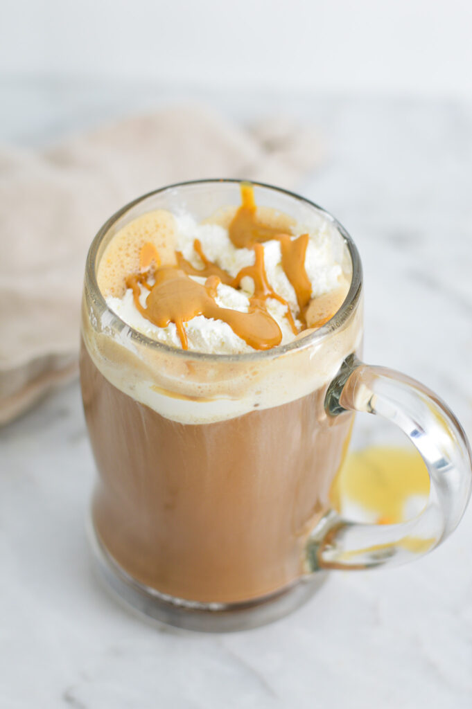 Peanut Butter Mocha in a glass mug, topped with whipped cream and melted peanut butter.