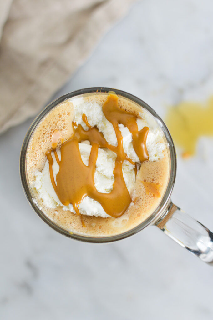 A mug filled with Peanut Butter Mocha, topped with soft whipped cream and melted peanut butter.