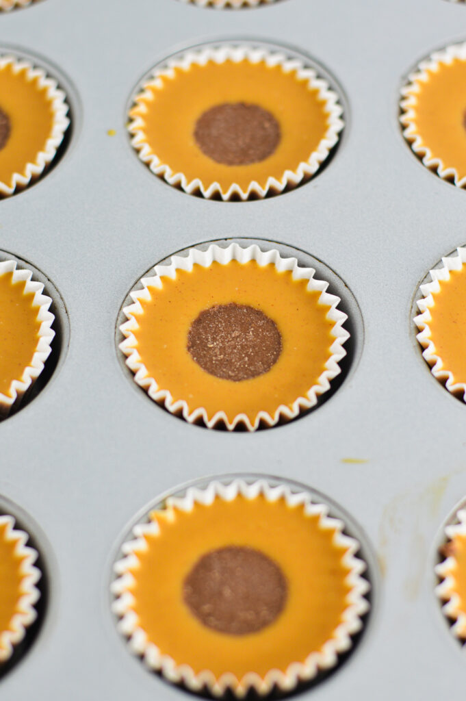 Reese's Peanut Butter Nutella Cups in mini paper liners in a mini muffin pan.