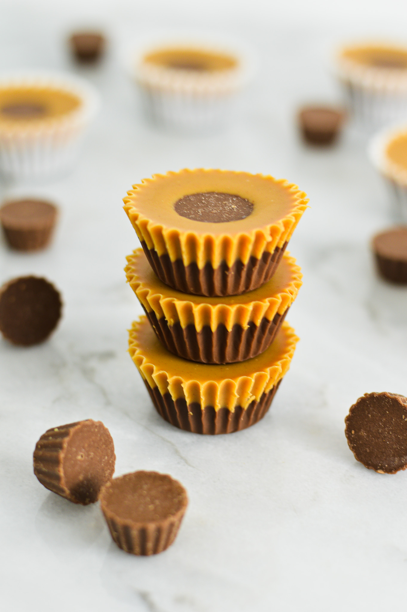 A stack of creamy Reese's Peanut Butter Nutella Cups, with defined Nutella and peanut butter layers and a mini Reese's cup peaking out of the top layer.