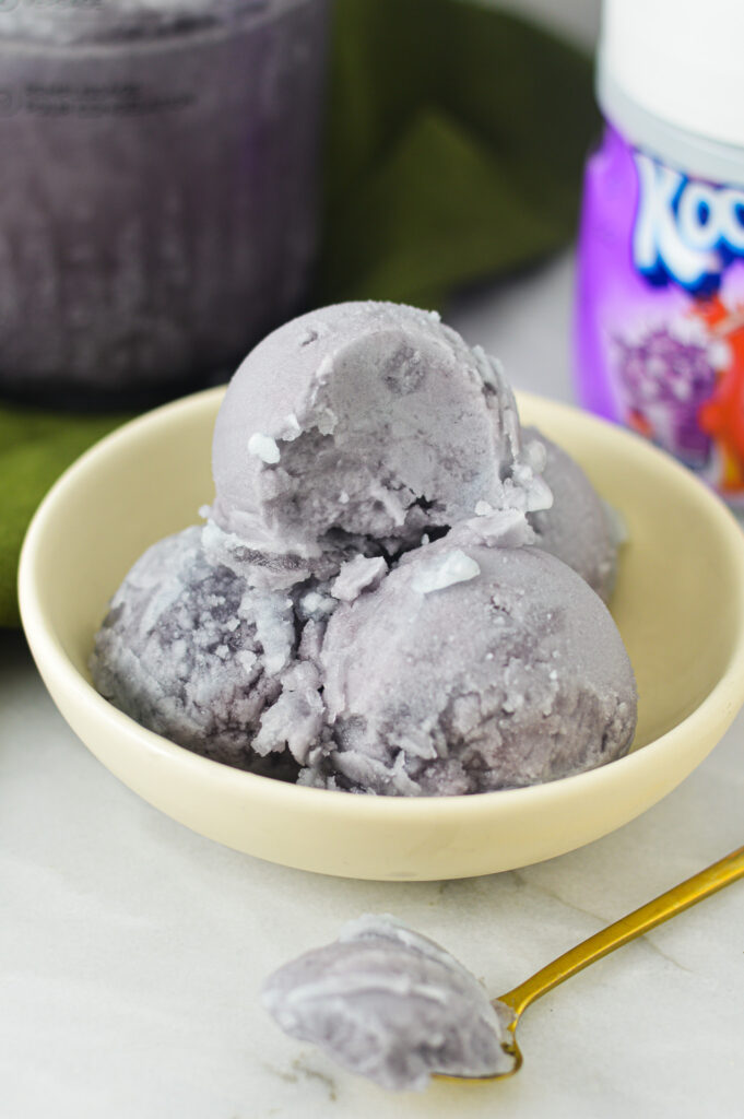 A small bowl of Ninja Creami Kool-Aid Italian Ice, with a spoonful taken out of the top scoop.