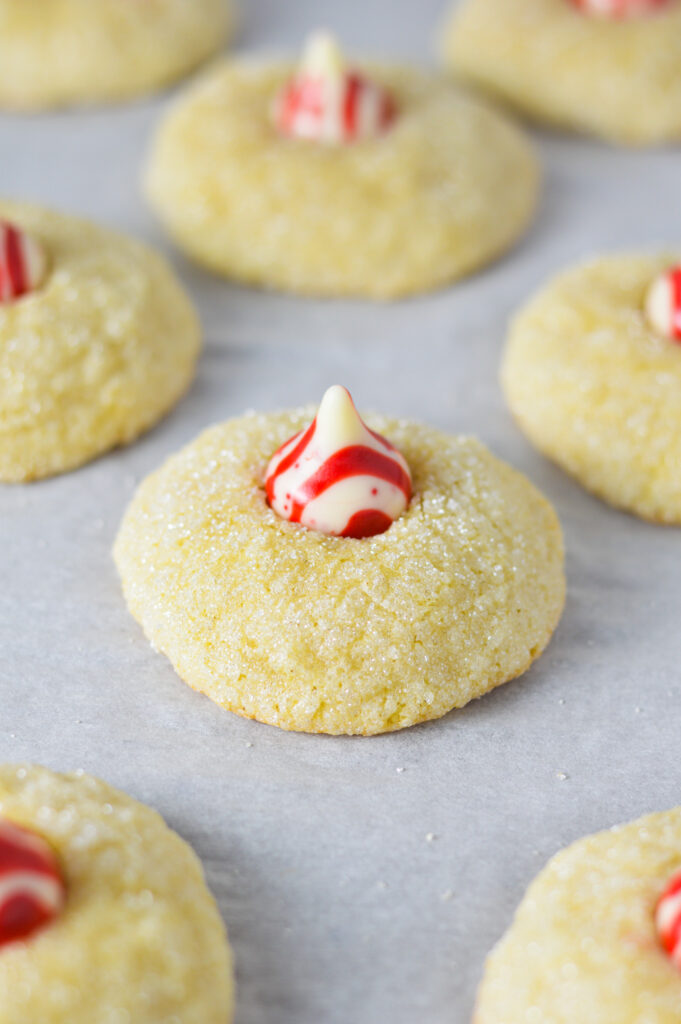 A parchment paper lined baking sheet with fluffy Kiss Cookies.