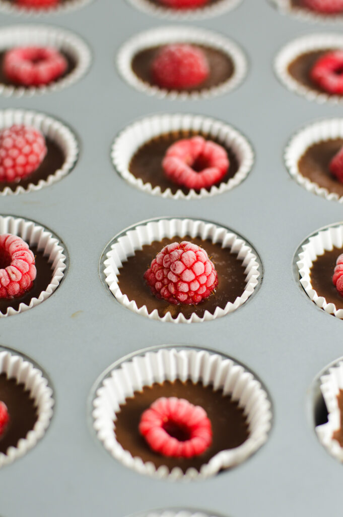 A mini muffin tin filled with Raspberry Nutella Cups in mini cupcake liners.