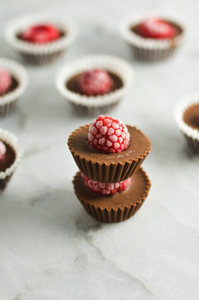 A stack of Raspberry Nutella Cups, with a frozen raspberry sticking out of each creamy Nutella cup.