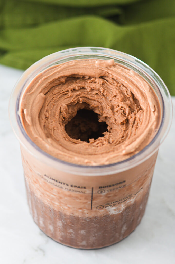 Rich Ninja Creami Lite Chocolate Pudding Ice Cream inside the Ninja Creami pint container.