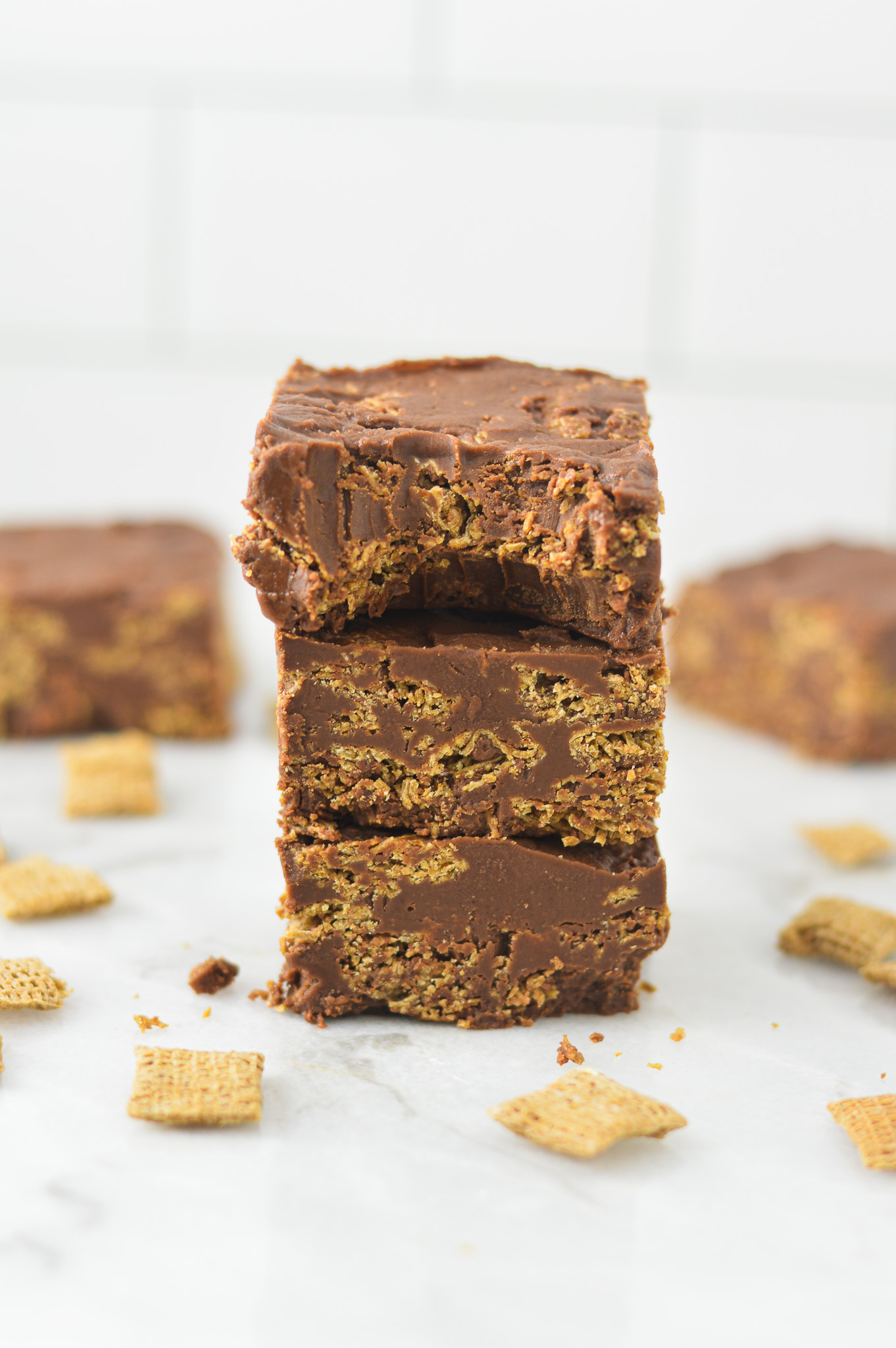 A stack of Peanut Butter and Chocolate Chex Bars with a bite taken out of the top car, showing