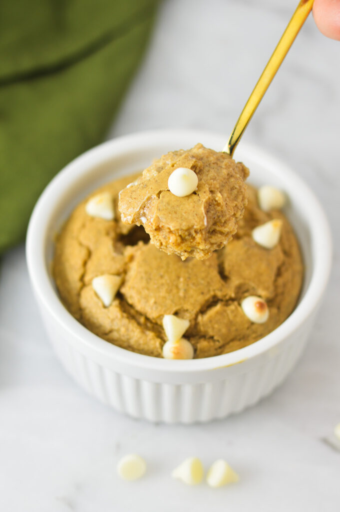 A small golden spoonful of White Chocolate Protein Blended Baked Oats, showing the fluffy texture.