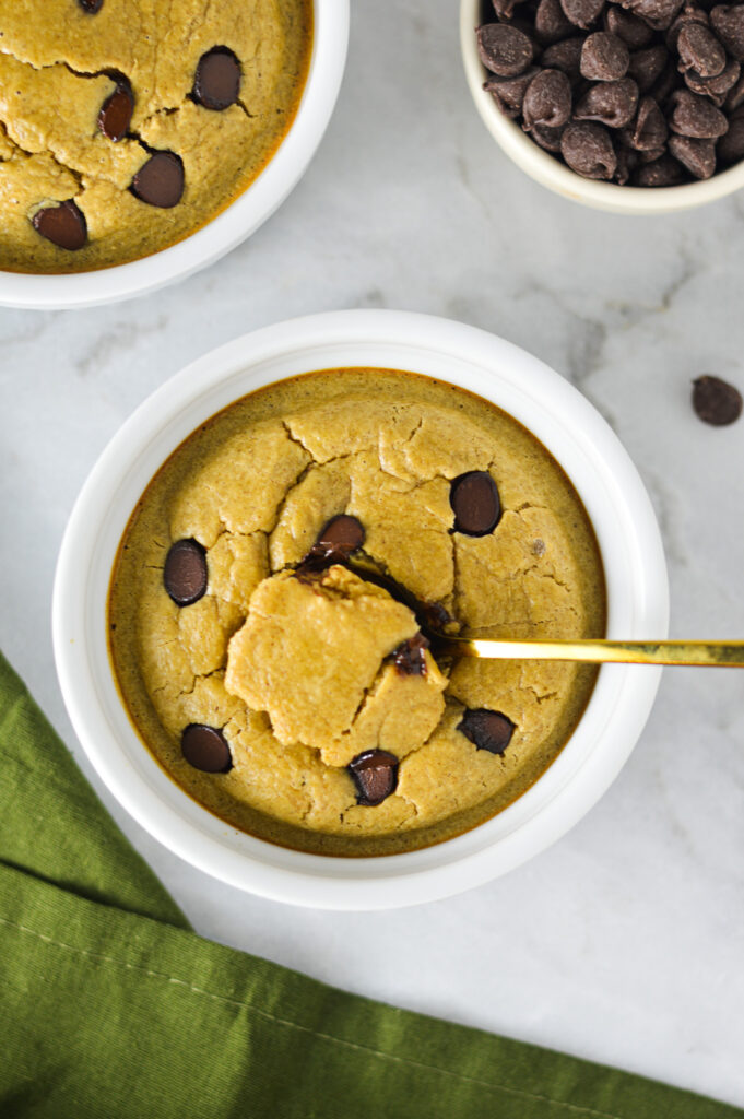 A gold spoon inside a bowl full of Chocolate Chip Protein Blended Baked Oats, showing the cake-like texture.