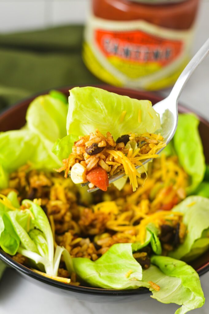 A forkful of Rice and Black Bean Salad being scooped out of a small bowl full of the vibrant salad.