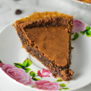 A small floral plate with a slice of Chocolate Chess Pie, showing the rich and fudgy filling.