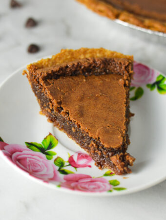 A small floral plate with a slice of Chocolate Chess Pie, showing the rich and fudgy filling.