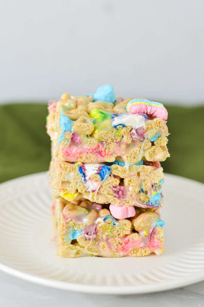 A stack of colorful Lucky Charms Treats on a small white plate.