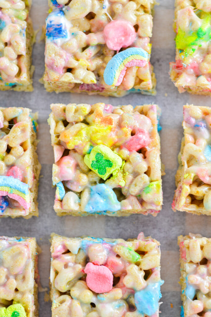 Colorful Lucky Charms cereal treat bars made with gooey marshmallow, packed with crunchy oat pieces and vibrant, pastel-hued marshmallow shapes.