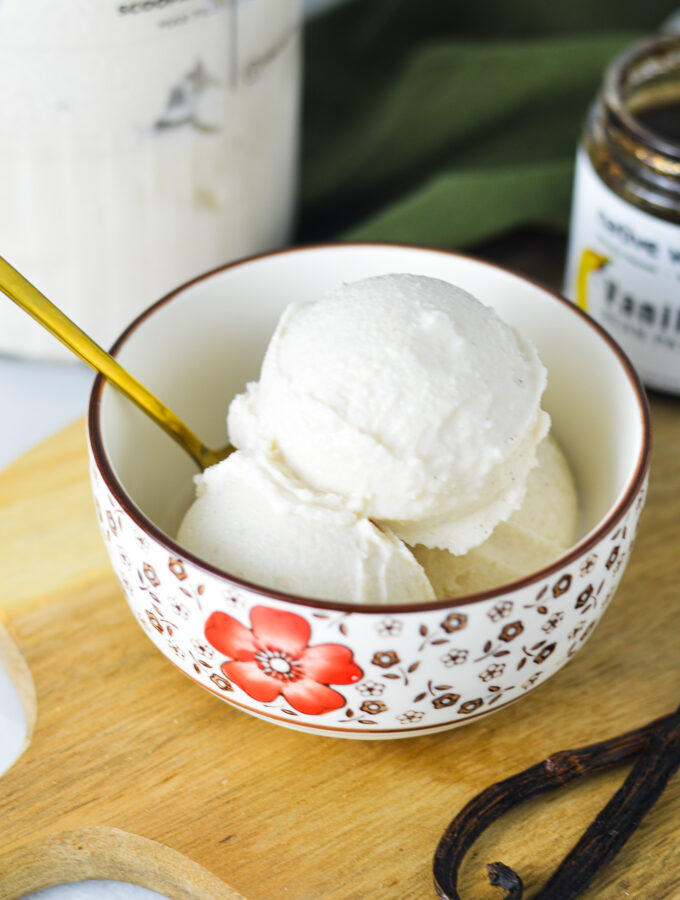 A bowl full of Ninja Creami Vanilla Bean Ice Cream, with a gold spoon sticking out of the bowl.