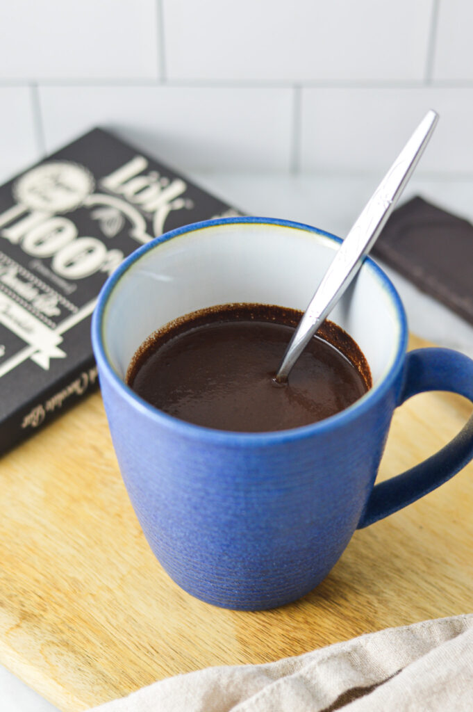 A small spoon in a large mug full of Rich Hot Chocolate.